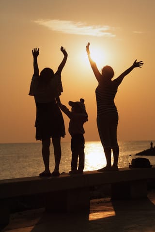 image two women and a child face the sea