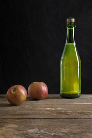 image cider bottle on table with apples